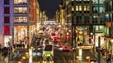 Abendlicher Verkehr auf der Friedrichstraße in Berlin: Autos, Bus und Straßenbahn stauen sich auf der belebten Einkaufsstraße.