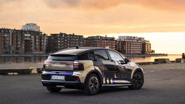 Audi A2 E-Tron Prototyp in silberner Tarnbeklebung aus Heckperspektive an einer Hafenpromenade.