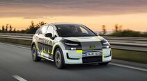 Audi A2 E-Tron Prototyp mit Tarnbeklebung fährt auf einer Autobahn aus Frontperspektive.