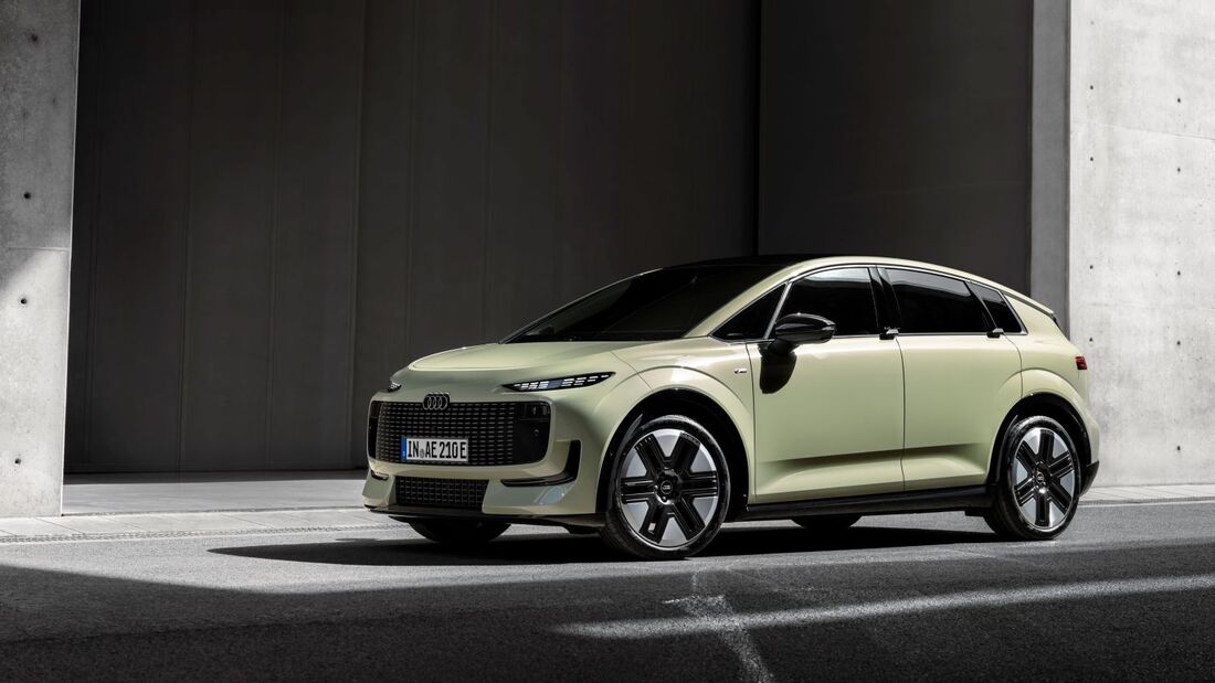 Audi A2 in hellgrüner Lackierung aus schräger Front-Seitenansicht vor einer modernen Gebäudefassade.