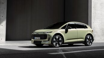 Audi A2 in hellgrüner Lackierung aus schräger Front-Seitenansicht vor einer modernen Gebäudefassade.