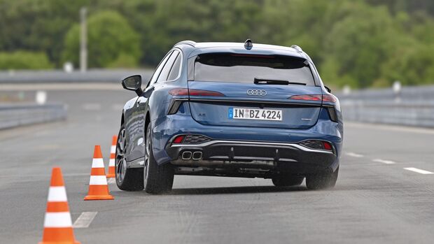 Audi A6 Avant TDI Quattro in Heckansicht bei einem Fahrmanöver zwischen Pylonen auf nasser Fahrbahn.