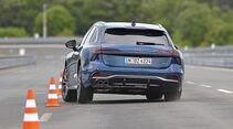 Audi A6 Avant TDI Quattro in Heckansicht bei einem Fahrmanöver zwischen Pylonen auf nasser Fahrbahn.