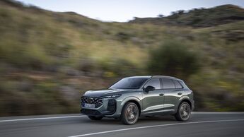 Audi Q3 in hellgrüner Lackierung während der Fahrt auf einer Landstraße, Front- und Seitenansicht.