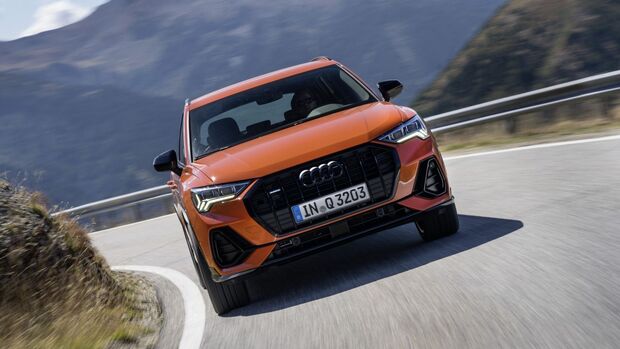 Audi Q3 in orange aus Frontansicht während der Fahrt auf kurviger Bergstraße