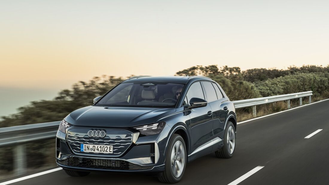 Audi Q4 e-tron fährt auf Landstraße mit Leitplanke bei Tageslicht