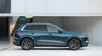 Audi Q7 Generation 3 in Seitenansicht vor moderner Architektur.