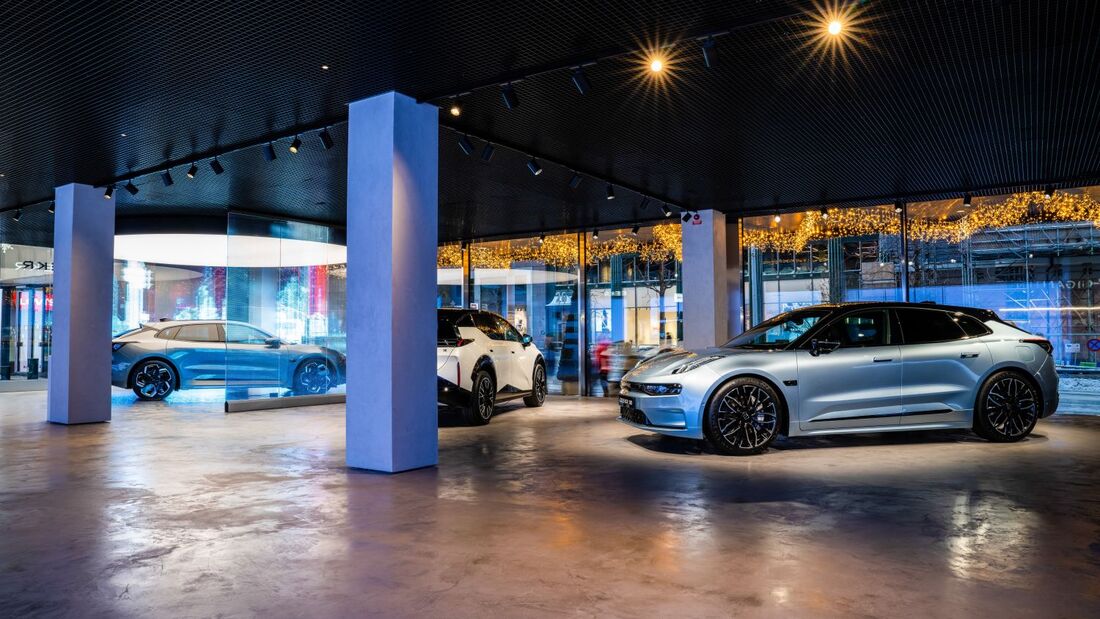 Ausstellungsfläche mit mehreren Zeekr Elektrofahrzeugen im Innenraum eines Showrooms mit großen Glasflächen.