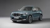 BMW X1 in Blaugrün, Frontansicht schräg von vorn im Studiohintergrund.