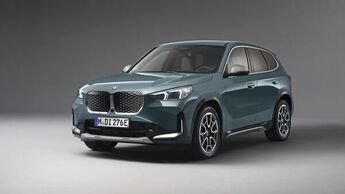 BMW X1 in Blaugrün, Frontansicht schräg von vorn im Studiohintergrund.