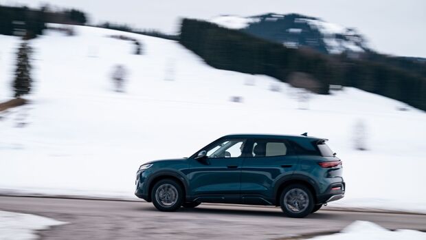 BYD Atto 2 DM-i in Seitenansicht während der Fahrt auf winterlicher Straße mit verschneiter Landschaft.