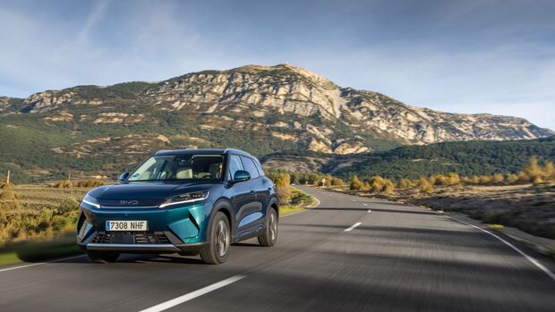 BYD Atto 2 in Fahrt auf einer Bergstraße mit Landschaft im Hintergrund.