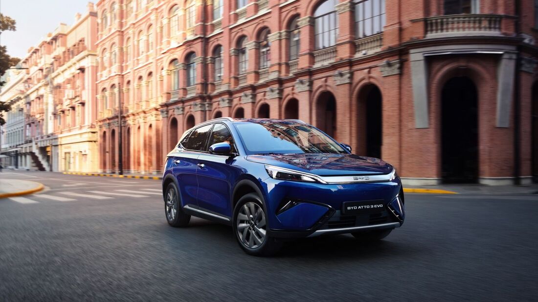 BYD Atto 3 Evo fährt durch eine Stadt mit historischer Architektur