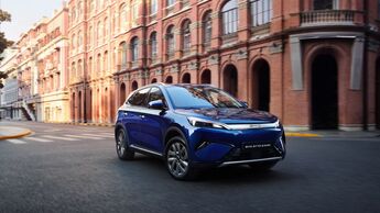 BYD Atto 3 Evo fährt durch eine Stadt mit historischer Architektur