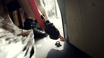 Befestigung eines Zurrgurts an einem im Fahrzeugboden integrierten Zurrpunkt zur Ladungssicherung in einem Nutzfahrzeug.