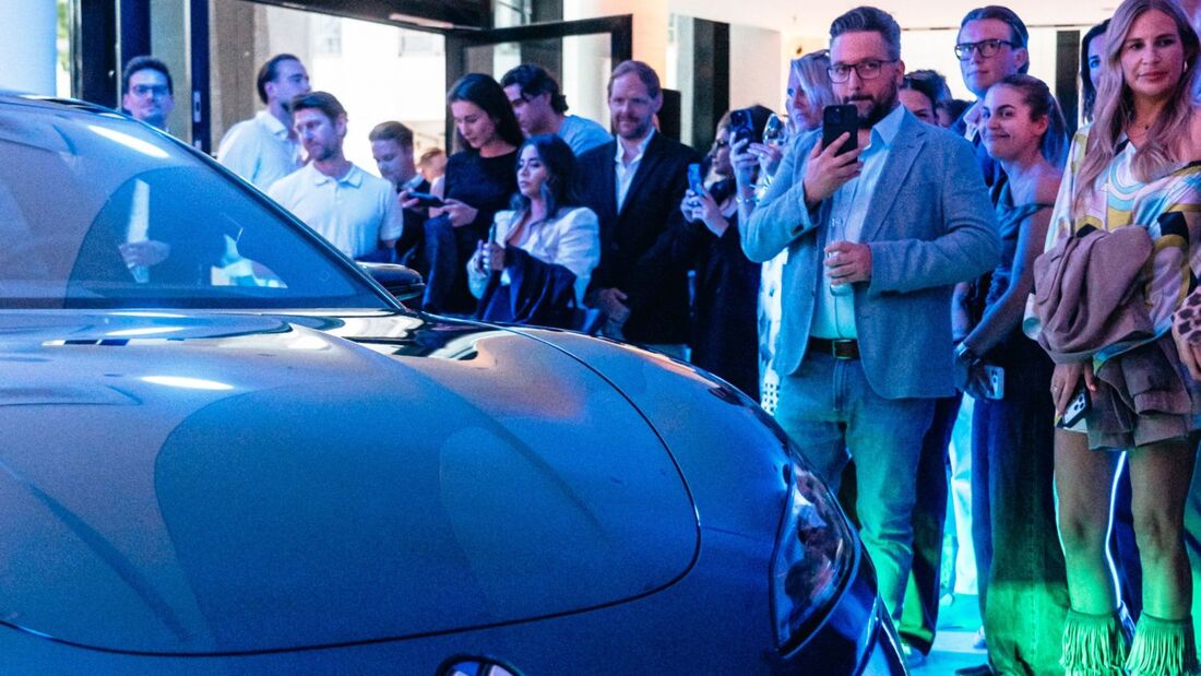 Besucher im Denza-Store Hamburg stehen vor einem ausgestellten Denza Z9GT der BYD-Premiummarke.