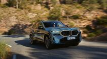 Blauer BMW XM Label auf Landstraße, leistungsstarkes Plug-in-Hybrid-SUV mit überarbeiteter Verbrennungstechnologie