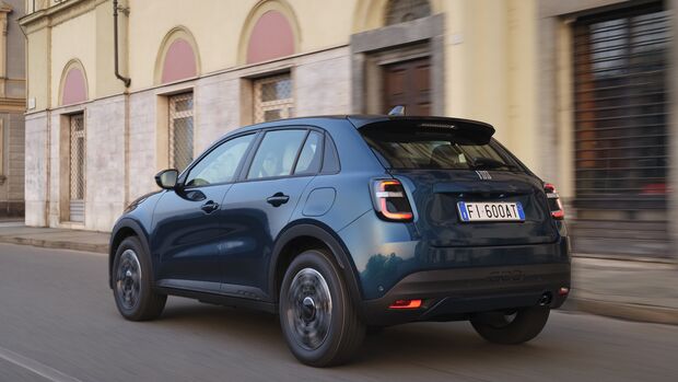 Blauer Fiat 600 Benziner in Heck-Schrägansicht während der Fahrt auf einer Straße.