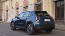 Blauer Fiat 600 Benziner in Heck-Schrägansicht während der Fahrt auf einer Straße.