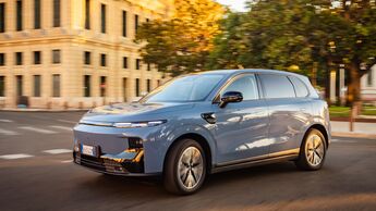 Blaues Leapmotor B10 SUV fährt auf einer Straße in der Stadt bei Abendlicht.