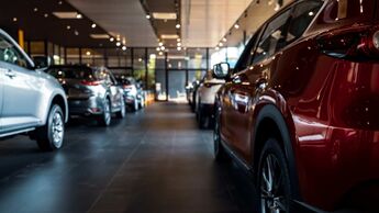 Blick durch einen Pkw-Showroom mit mehreren ausgestellten Fahrzeugen in einem Autohaus in Deutschland.