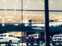 Blurred background with car dealership exterior. Abstract blurred photo of modern building motor showroom. Blur car show room office bokeh lights. Automobile retail shop