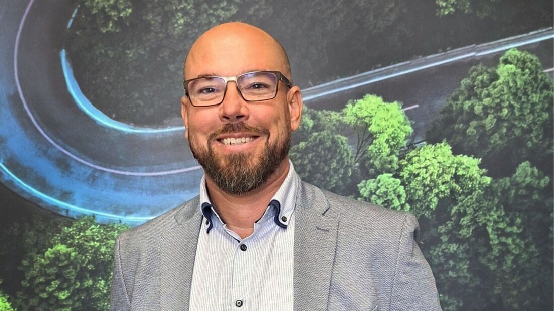 Christian Haiduck, neuer Head of Sales von MHC Mobility Deutschland, Porträtfoto vor Mobilitäts-Grafik.