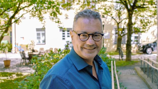 Christian Reiter steht im Freien vor einem Gebäude und blickt in die Kamera