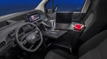 Citroën Berlingo mit Lenkrad, digitalem Cockpit, zentralem Touchscreen und ausgeklappter Arbeitsfläche mit Laptop im Innenraum.