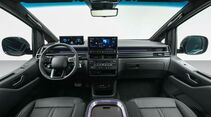 Cockpit des Hyundai Staria Elektro mit digitalem Kombiinstrument, zentralem Touchscreen, Multifunktionslenkrad und Klimabedienung.