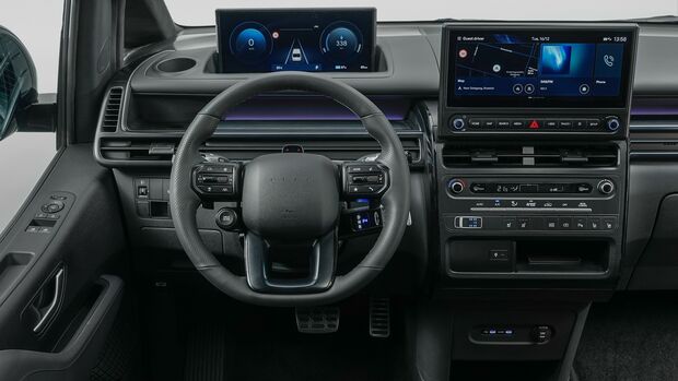 Cockpit des Hyundai Staria Elektro mit digitalem Kombiinstrument, zentralem Touchscreen und Multifunktionslenkrad.