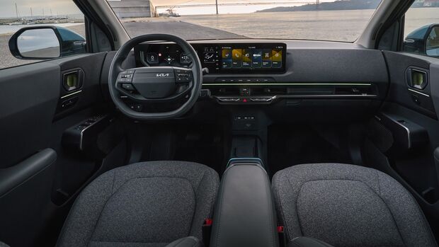 Cockpit des Kia EV2 mit Lenkrad, digitalem Kombiinstrument, zentralem Display und durchgehendem Armaturenbrett.