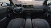 Cockpit des Kia EV2 mit Lenkrad, digitalem Kombiinstrument, zentralem Display und durchgehendem Armaturenbrett.