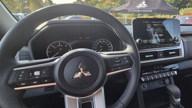 Cockpit des Mitsubishi L200 mit Multifunktionslenkrad, analogen Rundinstrumenten, zentralem Touchscreen und Klimaautomatik.