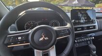 Cockpit des Mitsubishi L200 mit Multifunktionslenkrad, analogen Rundinstrumenten, zentralem Touchscreen und Klimaautomatik.