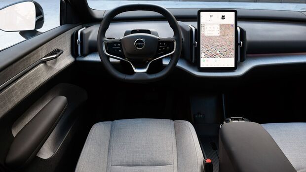 Cockpit des Volvo EX30 mit Lenkrad, zentralem Hochformat-Touchscreen und reduziert gestaltetem Armaturenbrett.
