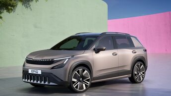 Der elektrische Kleinwagen Škoda Epiq steht frontal schräg vor einer farbigen, minimalistischen Architekturkulisse.