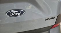 Detailaufnahme des AWD-Schriftzugs am Heck des Ford E-Transit Custom.