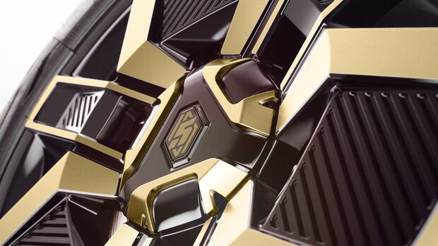 Detailaufnahme einer schwarz-goldenen Felge mit geometrischem Design am Renault 5 E-Tech Electric.