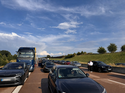 Dichter Stau mit Pkw und Lkw auf einer Autobahn – unzuverlässige Fahrzeiten können Firmenflotten zusätzliche Zeit und Geld kosten.