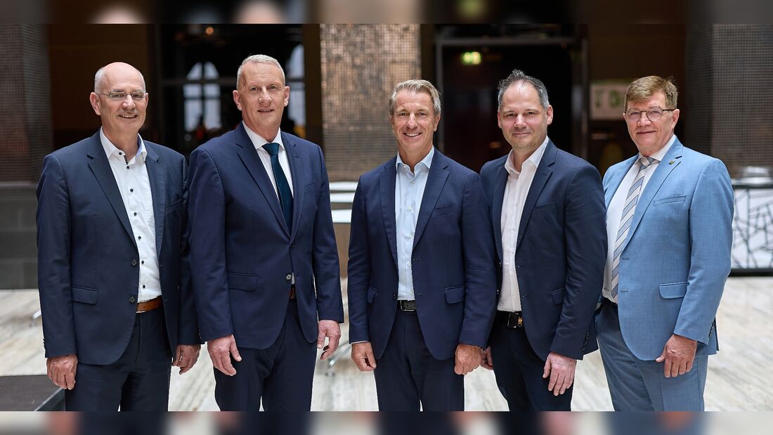 Die DAT-Geschäftsleitung steht gemeinsam für ein Gruppenfoto in einem Innenraum.