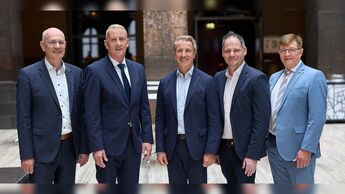 Die DAT-Geschäftsleitung steht gemeinsam für ein Gruppenfoto in einem Innenraum.
