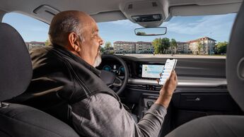 Dienstwagenfahrer nutzt ein Smartphone im Fahrzeug zur digitalen Erfassung von Fahrten