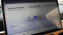 Display zeigt Energiefluss und Batteriestatus eines Elektroautos beim Entladen