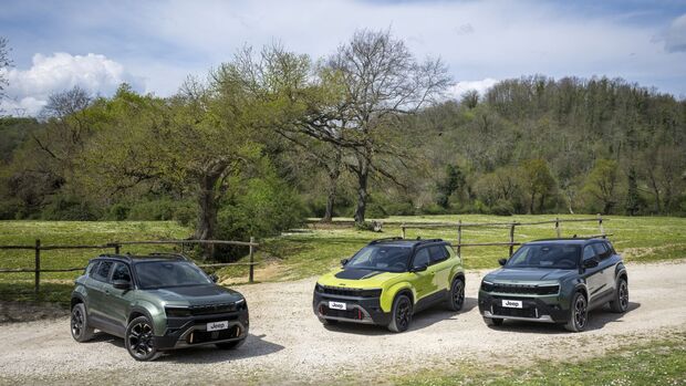 Drei Jeep Avenger SUV stehen auf einer Schotterfläche vor einer Landschaft mit Bäumen.