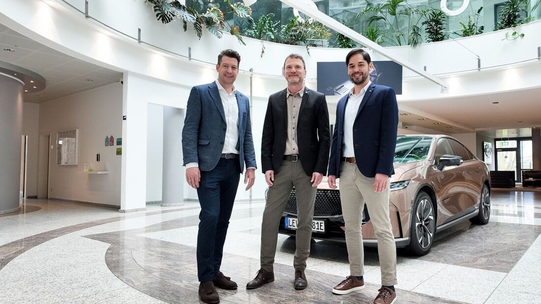 Drei Manager von Mazda Deutschland stehen in einem Showroom vor einem Fahrzeug.