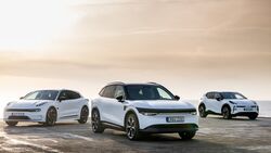 Drei weisse Zeekr Elektroautos stehen nebeneinander an einer Kueste, aufgenommen bei Tageslicht.