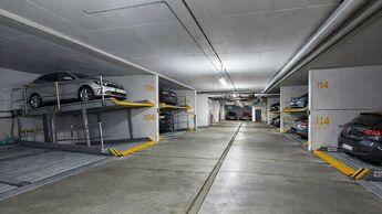 Duplex-Parksystem in einer Tiefgarage mit geparkten Fahrzeugen auf zwei Ebenen und nummerierten Stellplaetzen