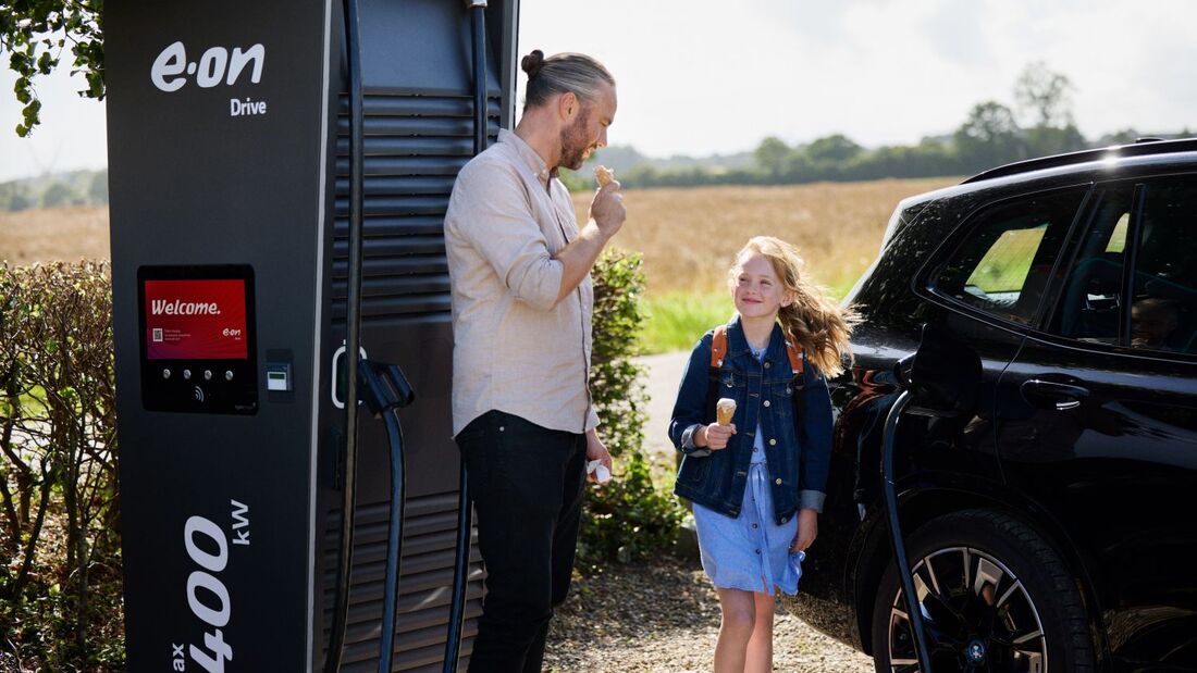 E.ON-Drive-Ladesäule mit einem Elektroauto während eines Ladevorgangs an einem öffentlichen Standort im ländlichen Raum.