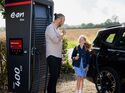 E.ON-Drive-Ladesäule mit einem Elektroauto während eines Ladevorgangs an einem öffentlichen Standort im ländlichen Raum.